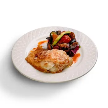 Lomo de bacalao gratinado con muselina suave de ajo y cama de verduras